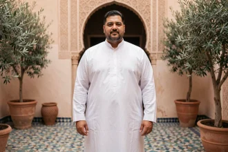 Homme arabe grande taille en thobe blanc brodé dans un riad marocain, vêtement traditionnel élégant pour homme fort